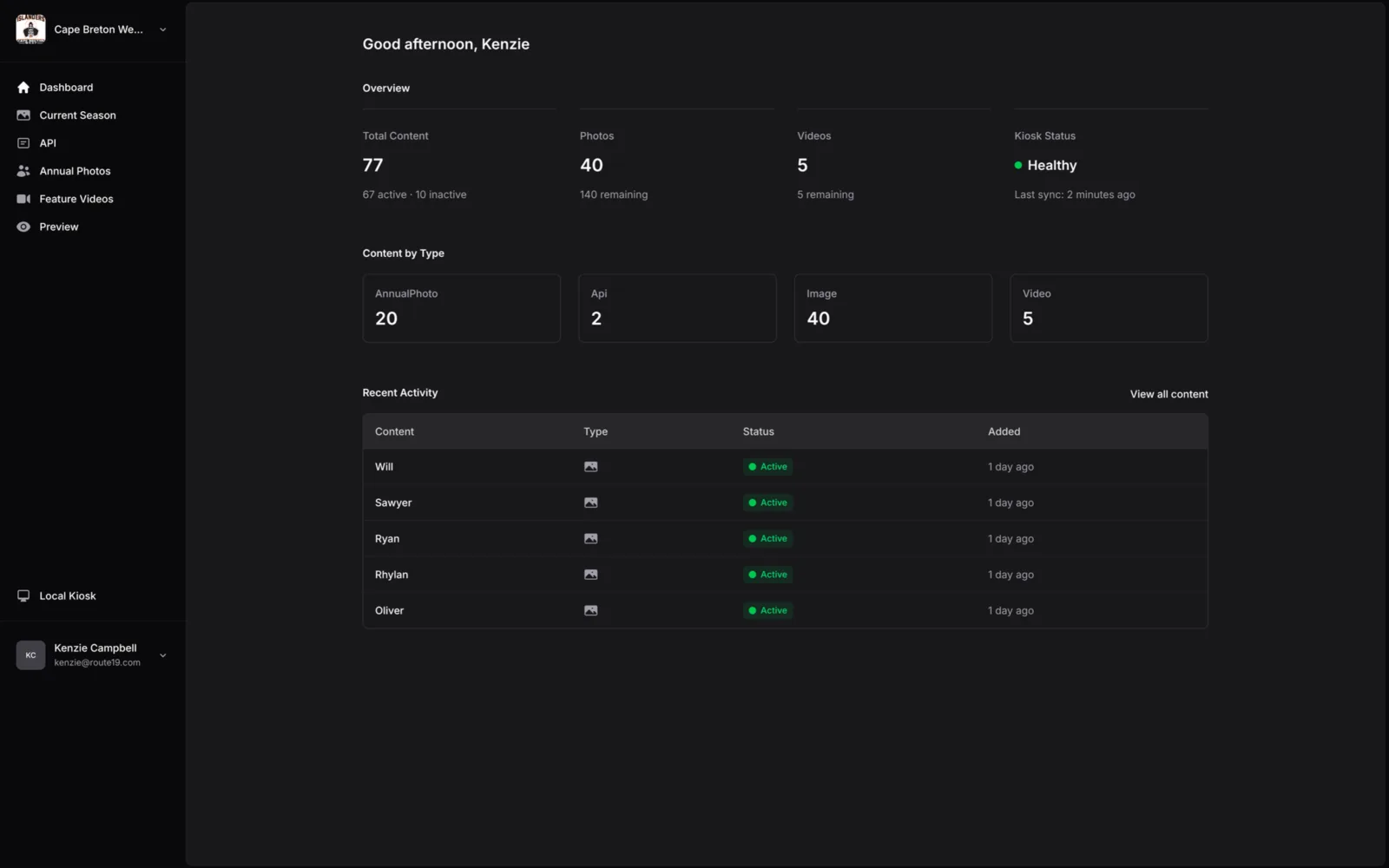 The KioskBook dashboard for a hockey team, showing totals for content, photos and videos, the kiosk’s status as healthy with its last sync two minutes ago, content counts by type, and recently added content.